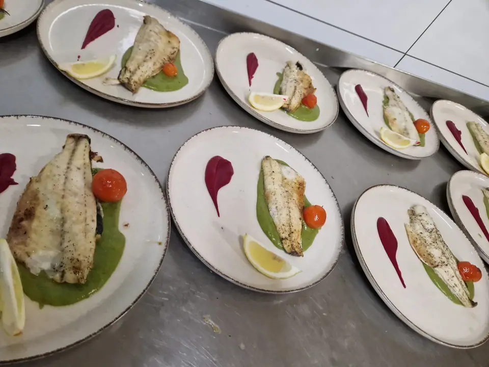 Gegrillte Fischfilets mit Gemüse und Zitrone, mehrfach angerichtet