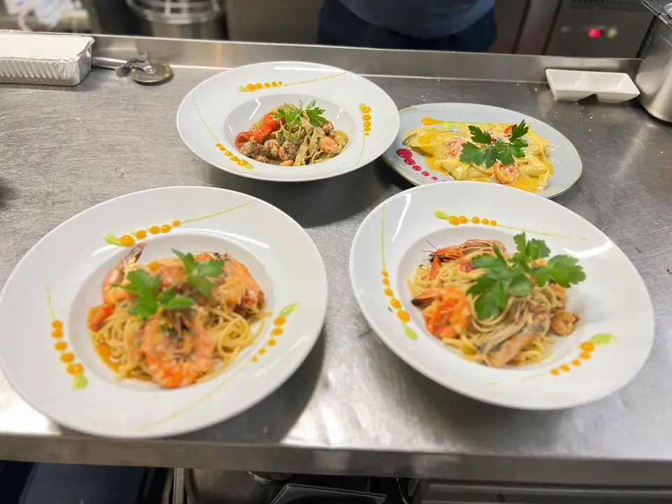 Pasta mit Meeresfrüchten und frischen Kräutern auf weißen Tellern