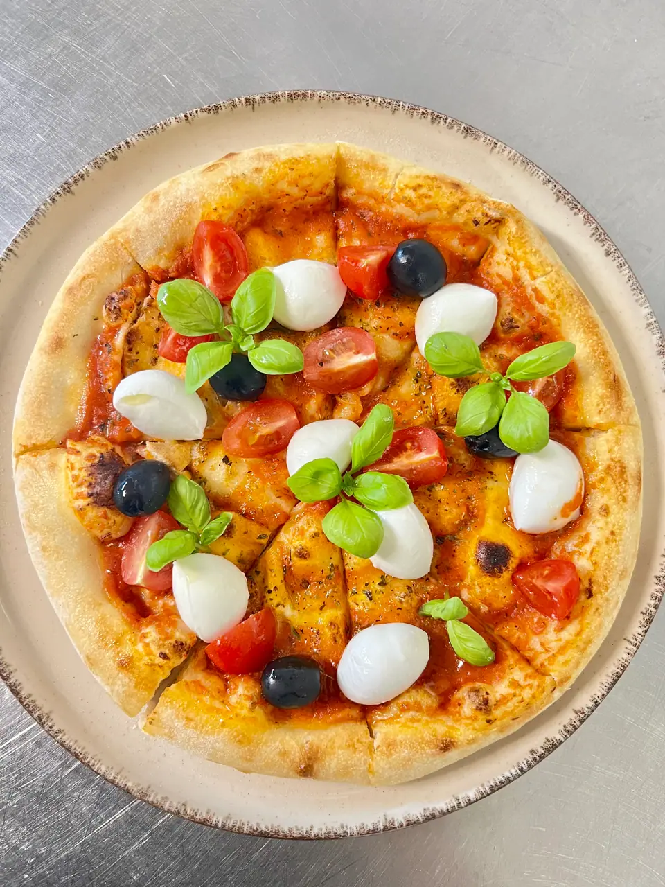 Pizza mit Mozzarella, Kirschtomaten und Basilikum